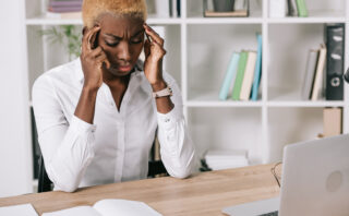 Stressed businesswoman holding head