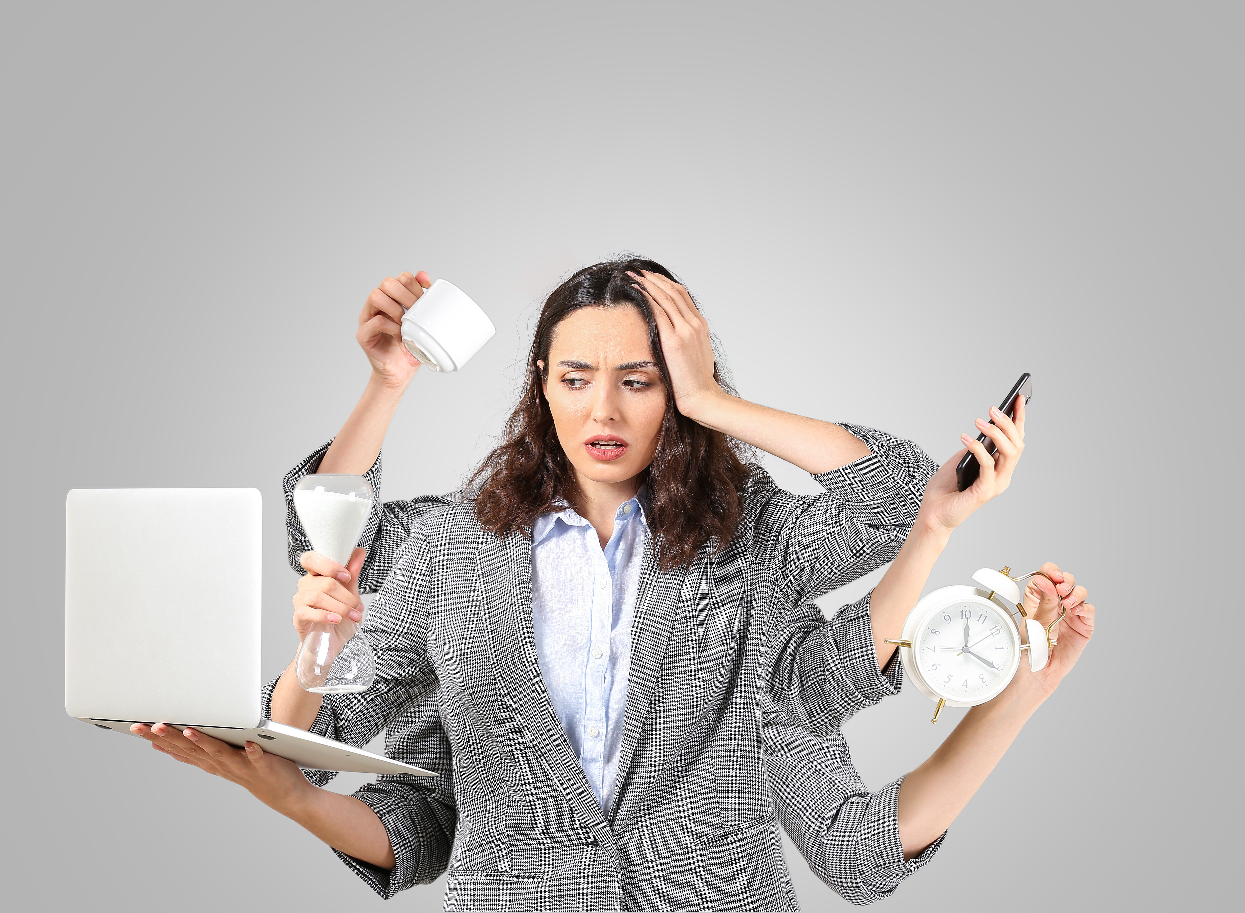 Stressed businesswoman with a lot of work to do on grey backgrou